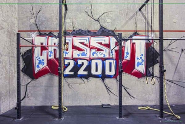 Crossfit 2200 graffiti on gym wall with fitness equipment.