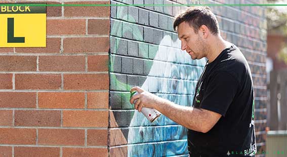 graffiti artist painting a mural within a school