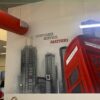 Modern tattoo studio interior with artwork and a red phone booth display.
