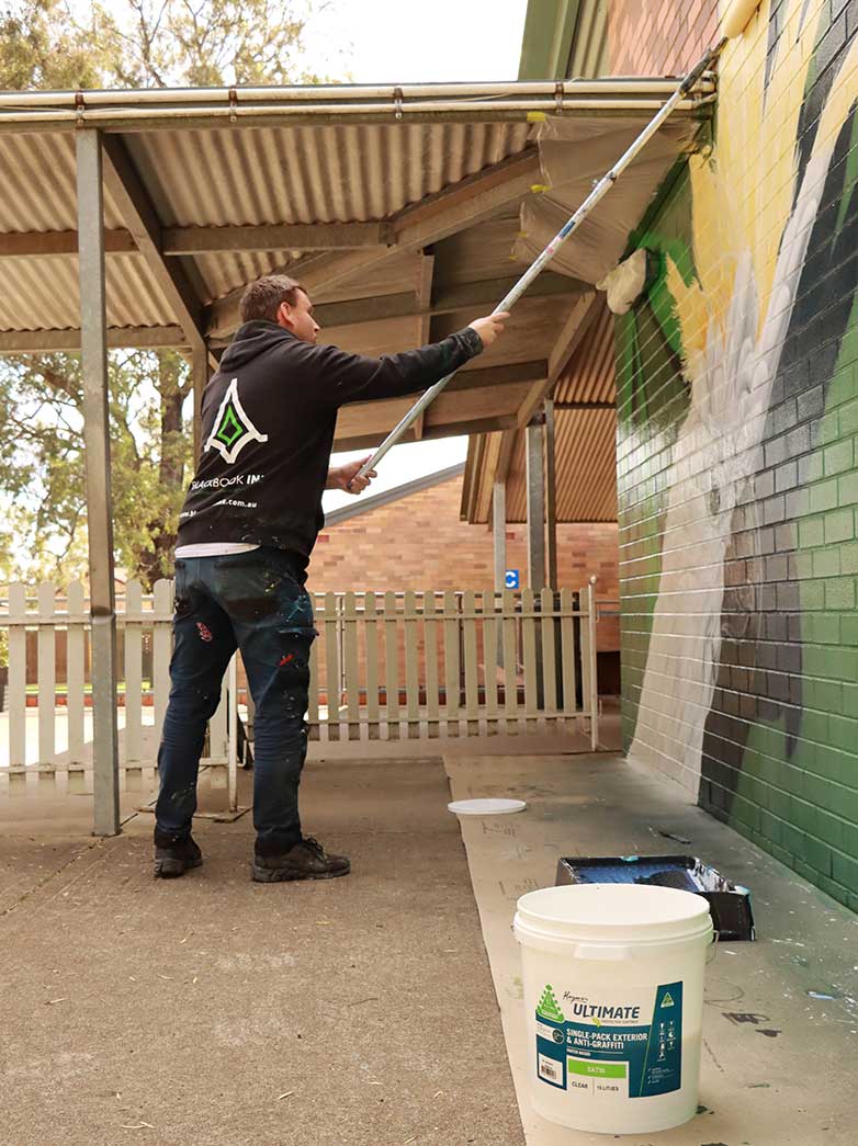 Graffiti removal services sydney - applying anti graffiti coating to wall