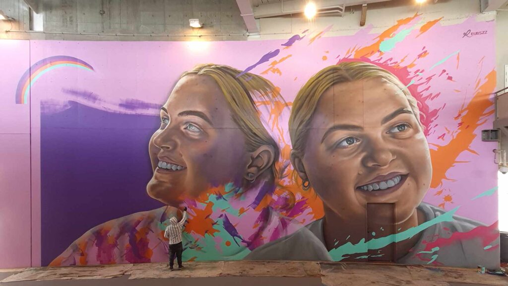 large scale mural painte by Reubszz