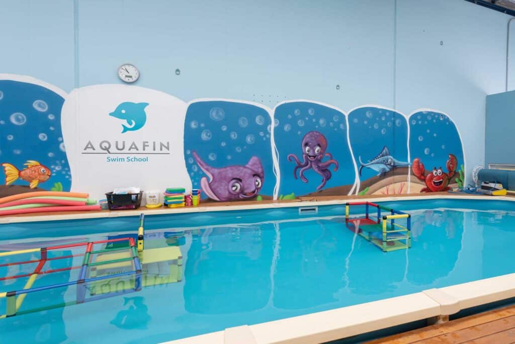 Indoor swimming pool at Blackbook Ink Swim School with colourful aquatic mural.
