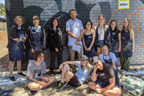 Group shot of students and artist during a mural workshop