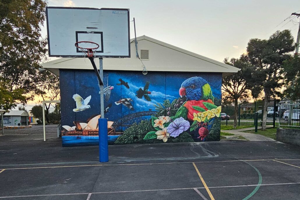Colorful mural featuring birds and flowers at Blackbook Ink tattoo studio.