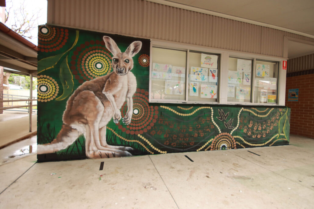 Colourful school mural with a kangaroo and Aboriginal art patterns.